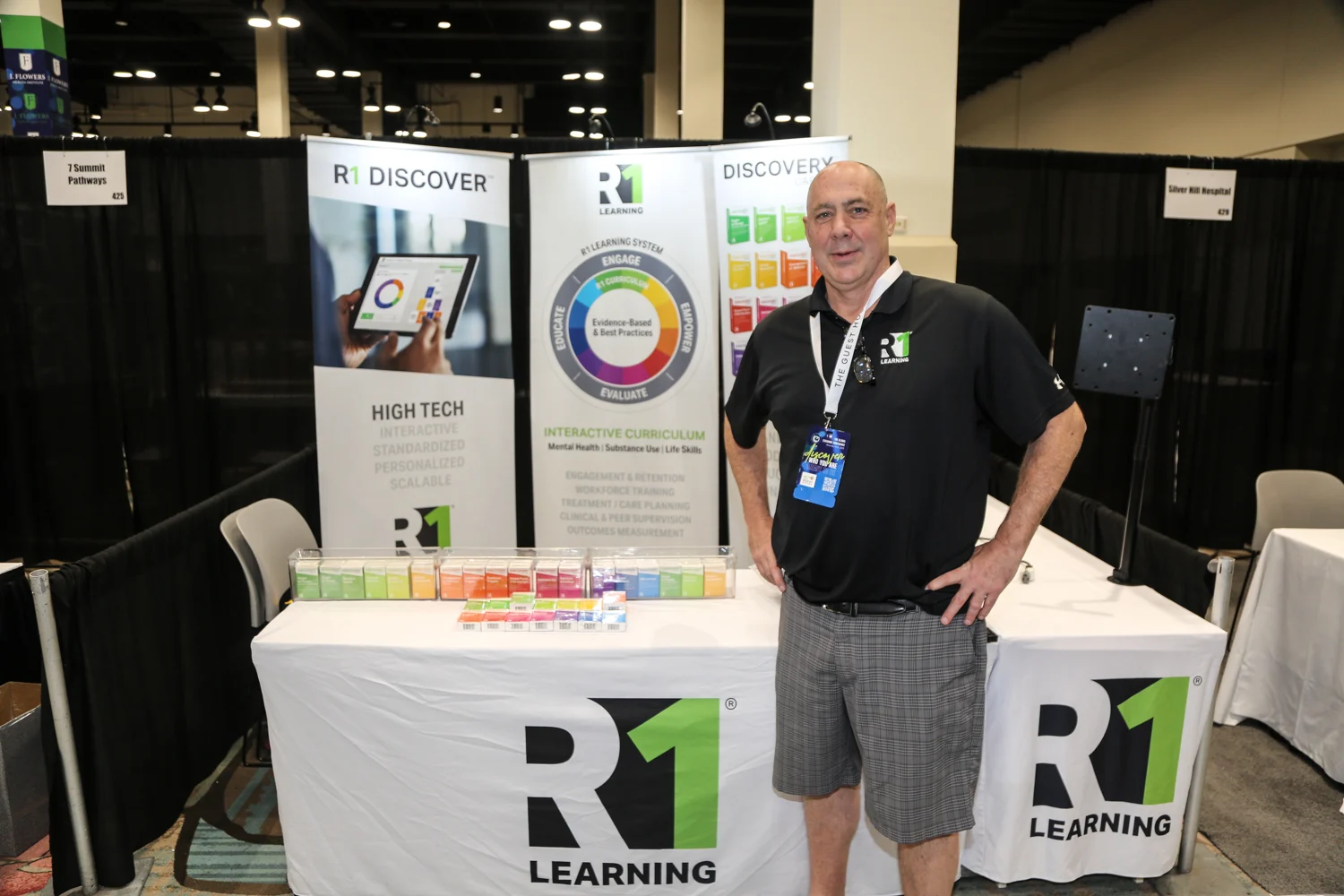 The Global Exchange Conference Exhibition Hall - Man standing in front of a stand